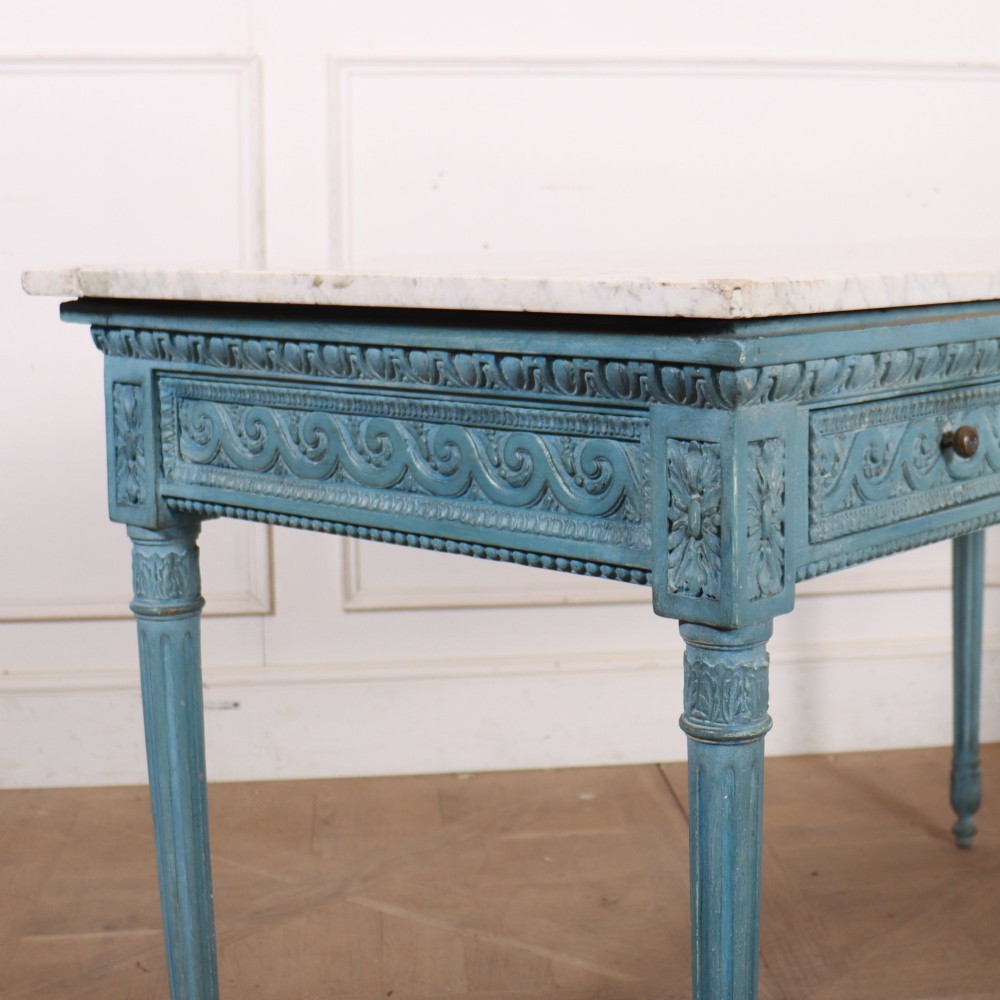 An Italian Neoclassical style light blue painted console table featuring a white marble top, three carved frieze drawers, and fluted legs. View XI