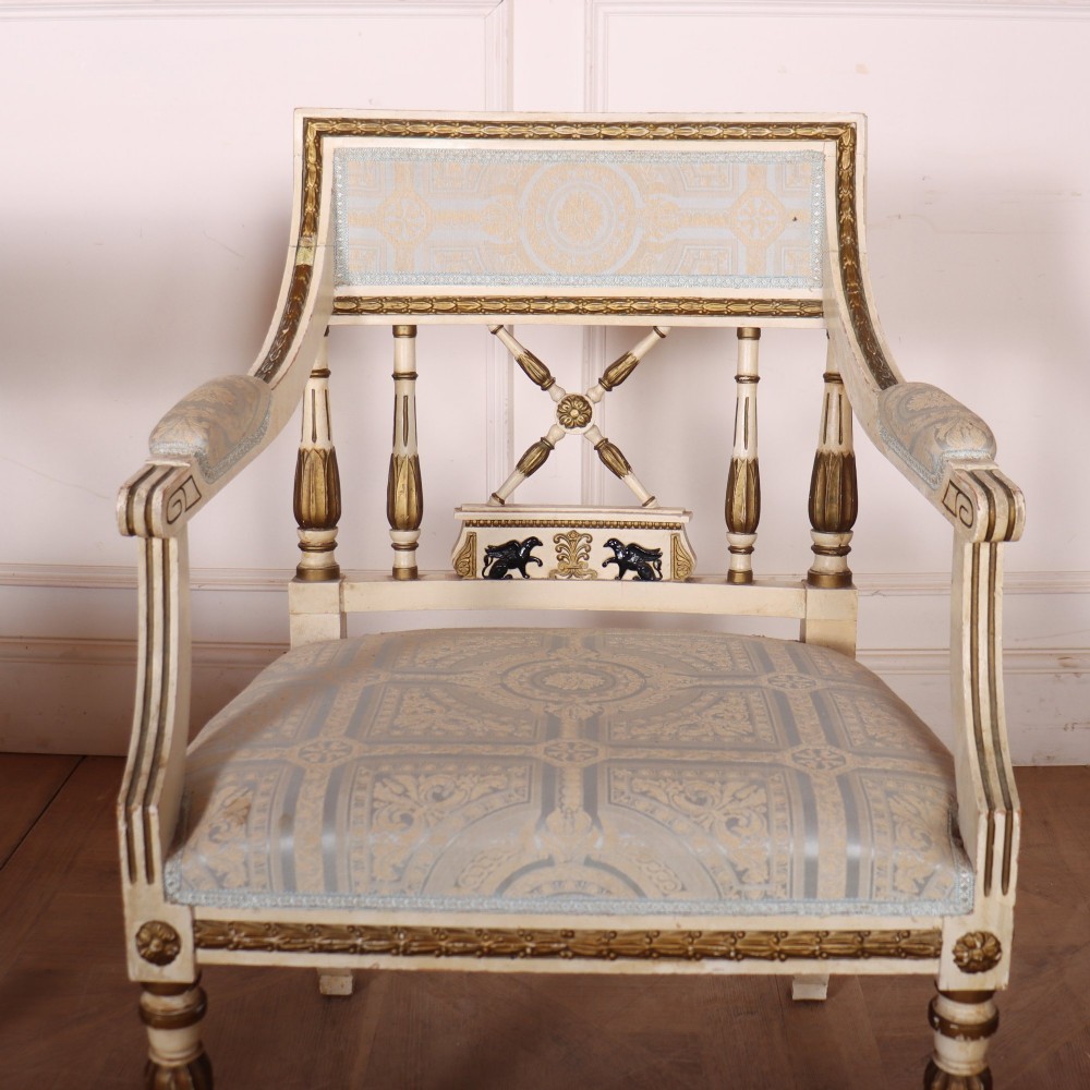 A pair of Swedish Empire style armchairs with pale cream and gilt painted frames, X-back spindle details, and light blue patterned fabric upholstery. View VIII