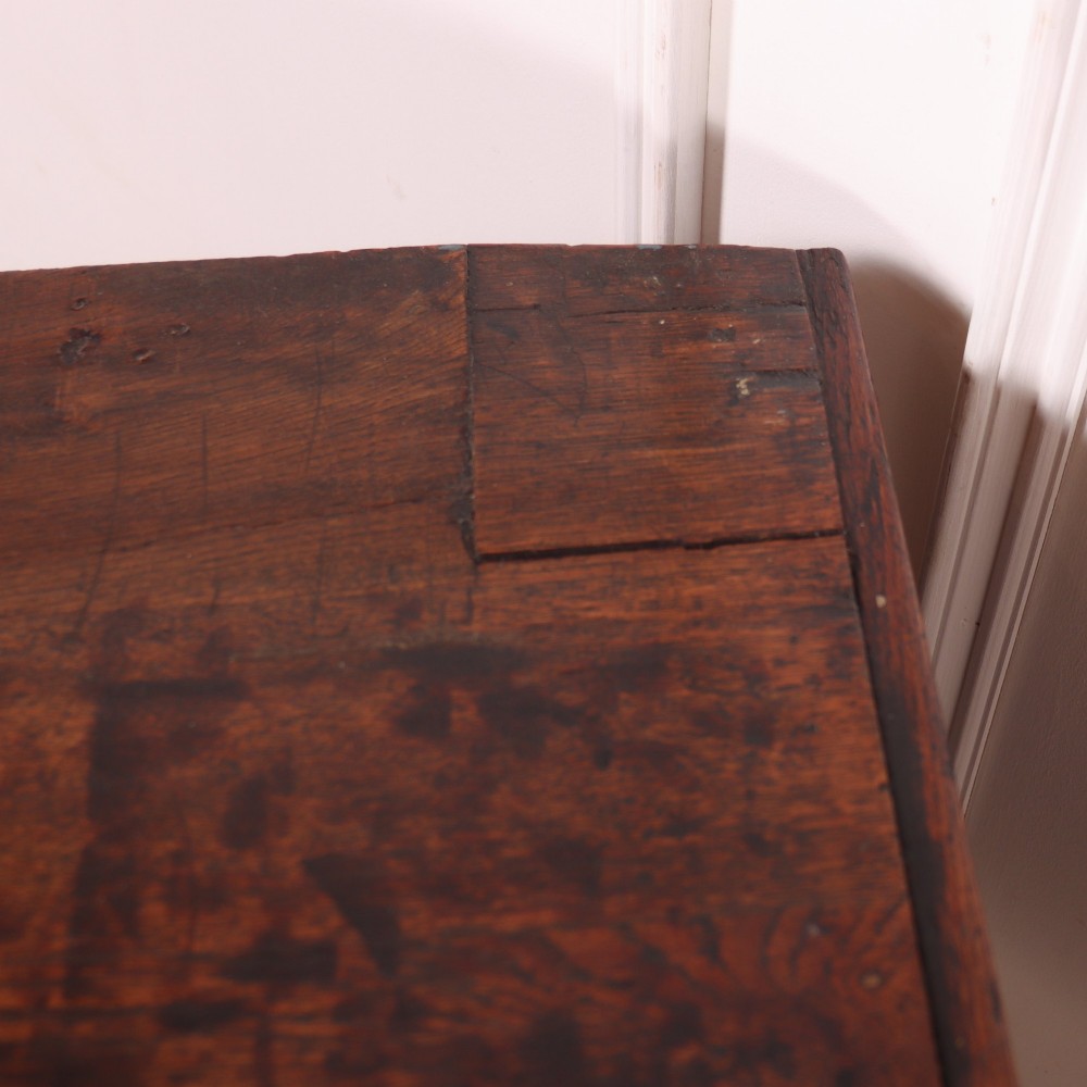 An eighteenth-century English oak dresser base featuring three drawers with brass swan-neck handles, raised on four slender straight legs. View XI