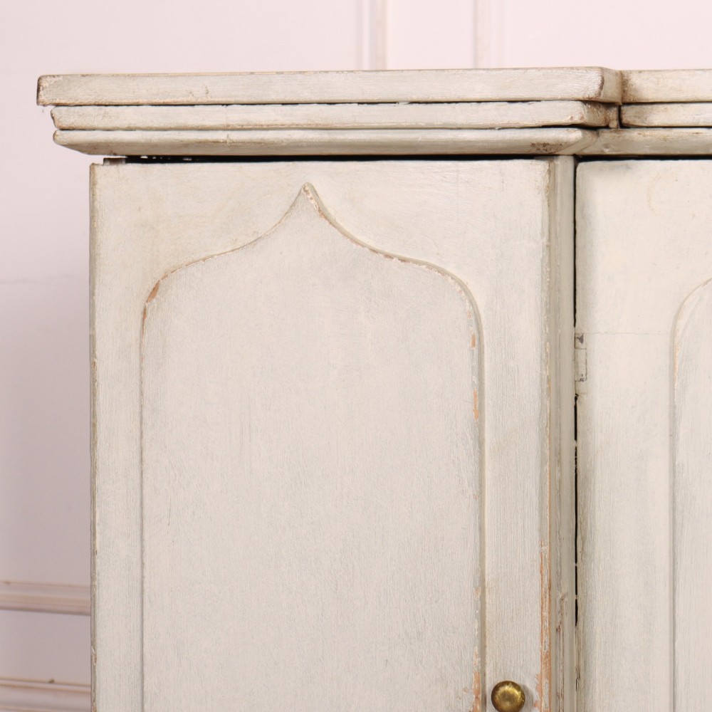 An off-white painted breakfront dresser base featuring four cupboard doors with arched panel mouldings and small brass knobs. View IV
