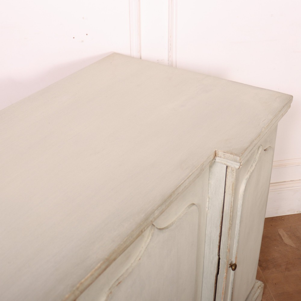 An off-white painted breakfront dresser base featuring four cupboard doors with arched panel mouldings and small brass knobs. View XII