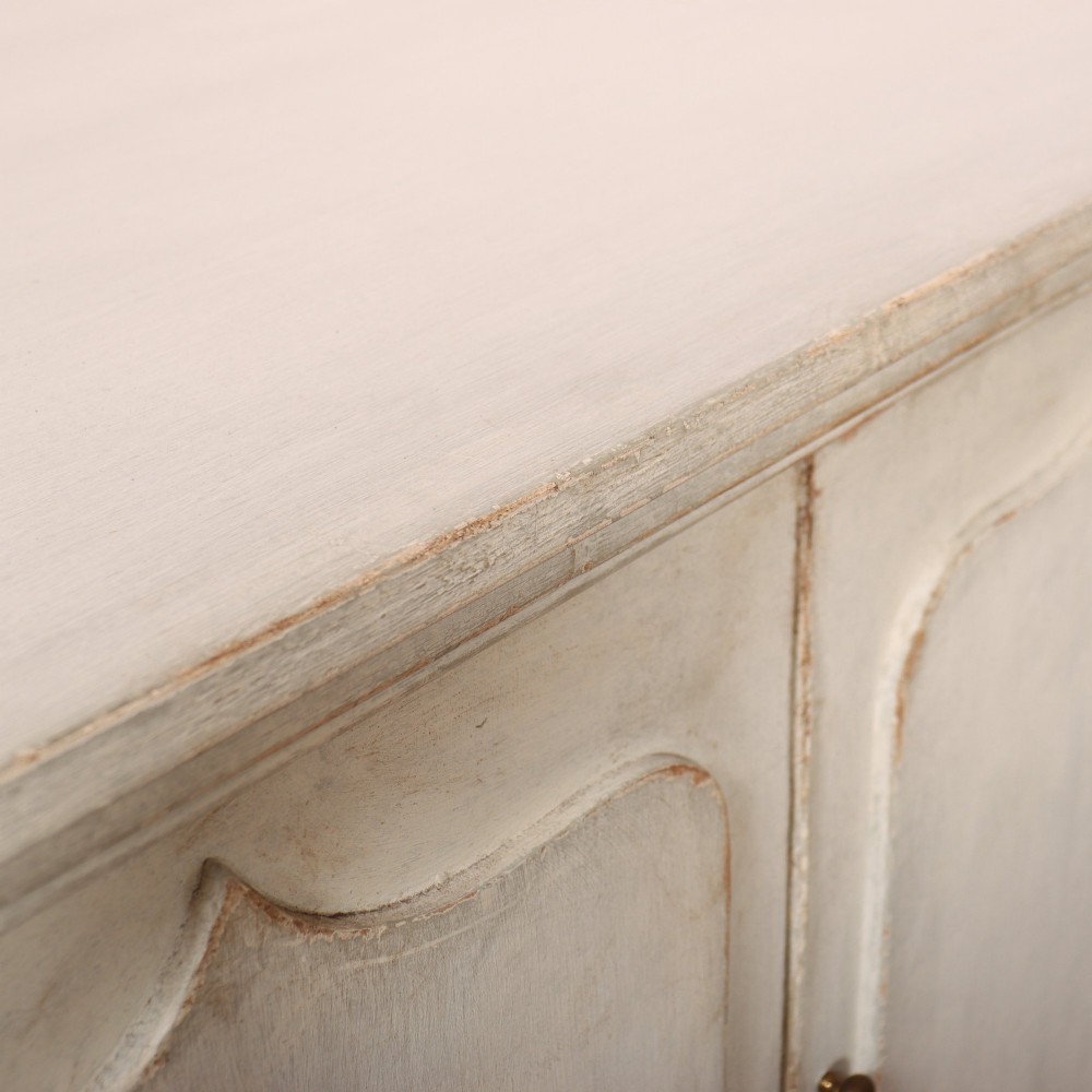 An off-white painted breakfront dresser base featuring four cupboard doors with arched panel mouldings and small brass knobs. View XIII