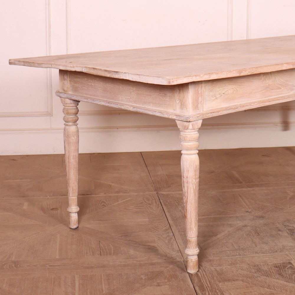 A 19th-century Spanish rustic elm dining table featuring a pale natural finish, four turned legs, and a single frieze drawer with a metal ring pull. View V