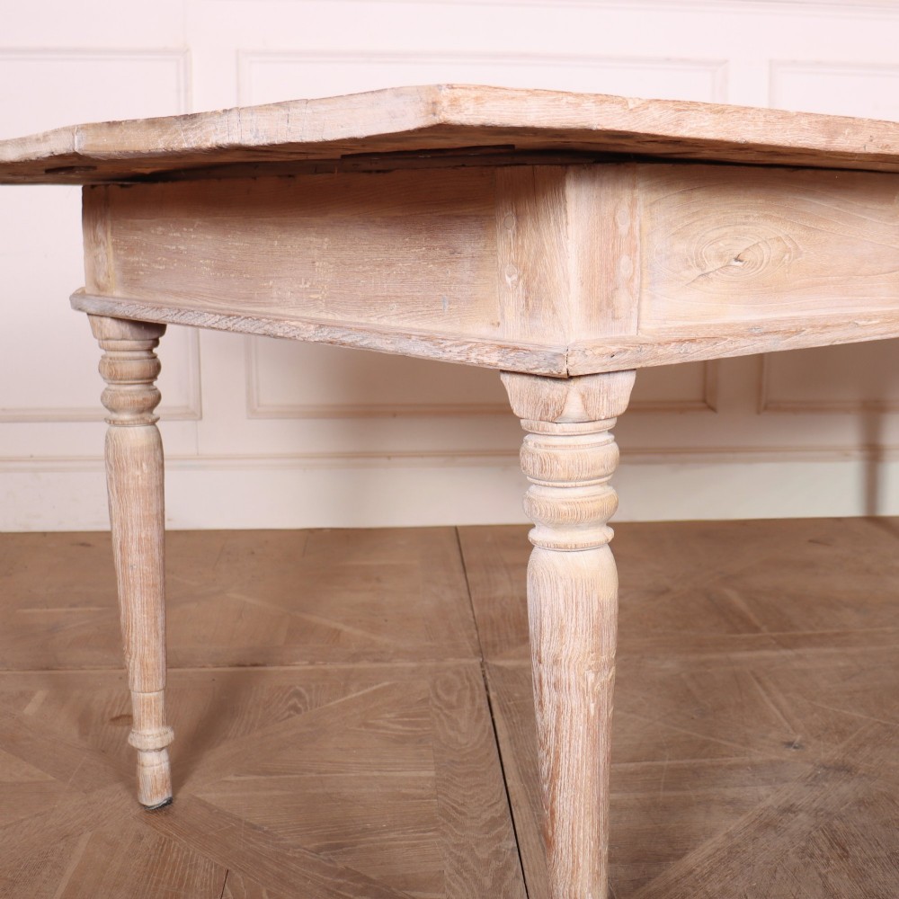 A 19th-century Spanish rustic elm dining table featuring a pale natural finish, four turned legs, and a single frieze drawer with a metal ring pull. View VI