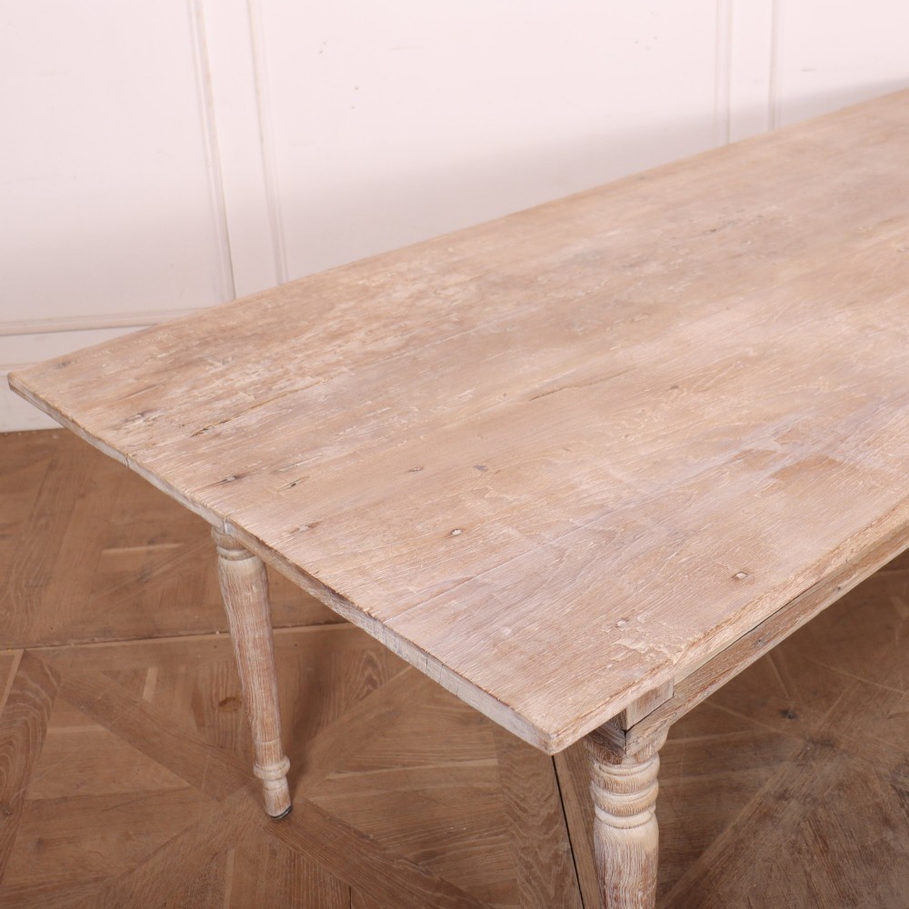 A 19th-century Spanish rustic elm dining table featuring a pale natural finish, four turned legs, and a single frieze drawer with a metal ring pull. View VII