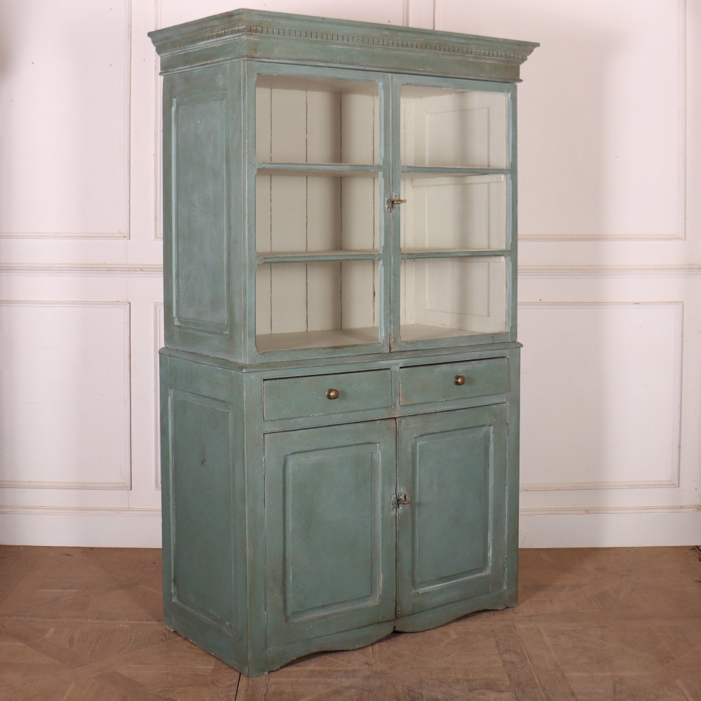 A tall two-part painted muted blue wood cabinet featuring an upper section with two glazed glass doors over a lower cupboard base with two drawers and panelled doors. View XIII