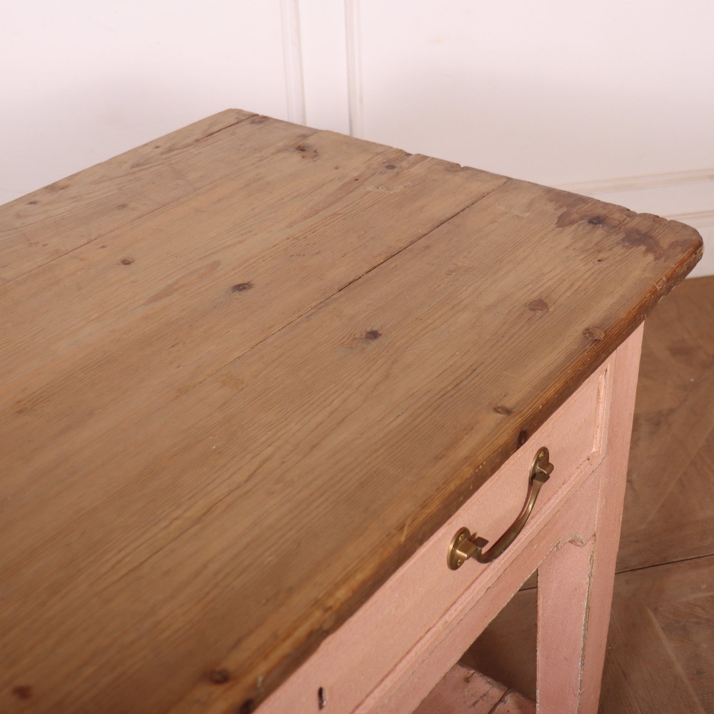 A Scottish farmhouse potboard dresser base with a painted pink frame, wide drawers fitted with brass handles, and an open lower wooden shelf. View XIII