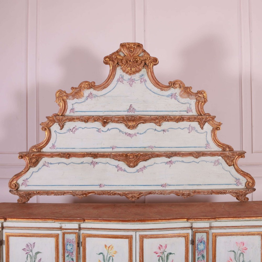 An eighteenth-century Venetian painted sideboard featuring floral polychrome panels, giltwood mouldings, and a tiered decorative pediment. View VII