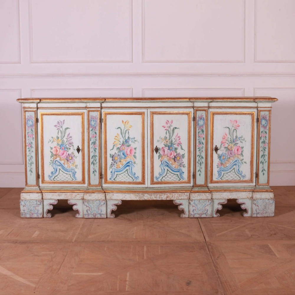 An eighteenth-century Venetian painted sideboard featuring floral polychrome panels, giltwood mouldings, and a tiered decorative pediment. View VIII