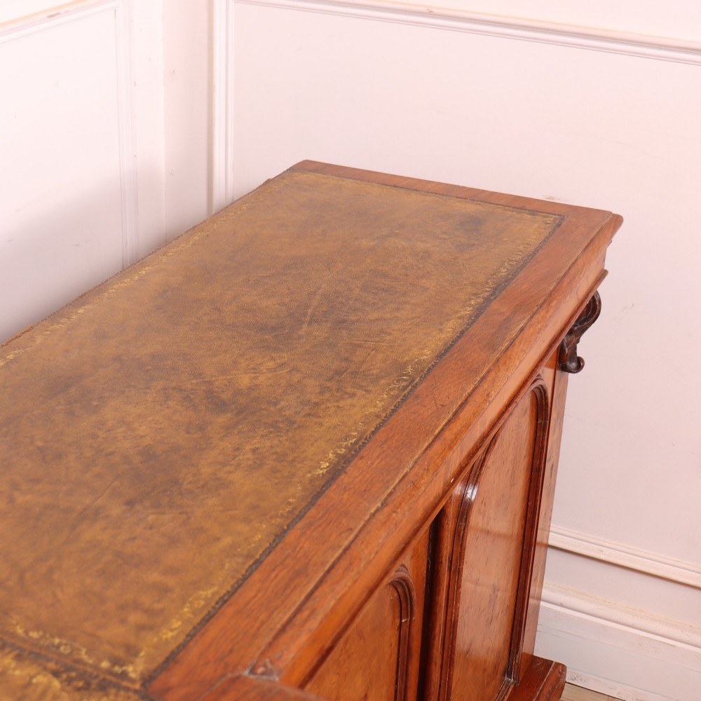 An antique English burr walnut dresser base featuring six arched cupboard doors with hand-carved decorative corbels along the top moulding. View XIII