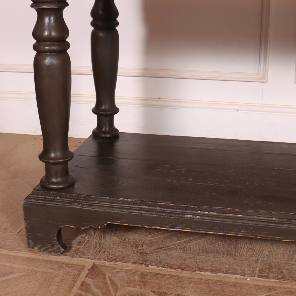 An antique dark grey painted English potboard dresser base featuring four drawers with brass handles, turned legs, and an open lower shelf. View III