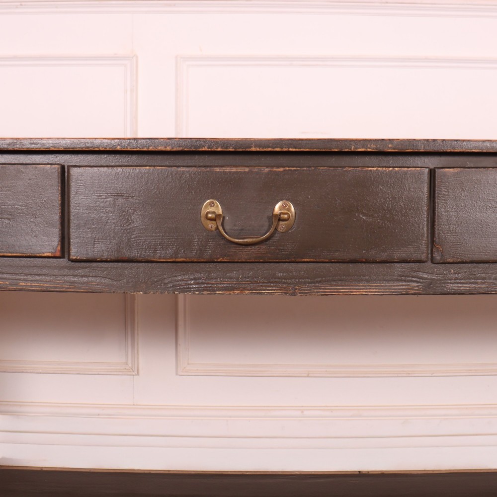 An antique dark grey painted English potboard dresser base featuring four drawers with brass handles, turned legs, and an open lower shelf. View IV