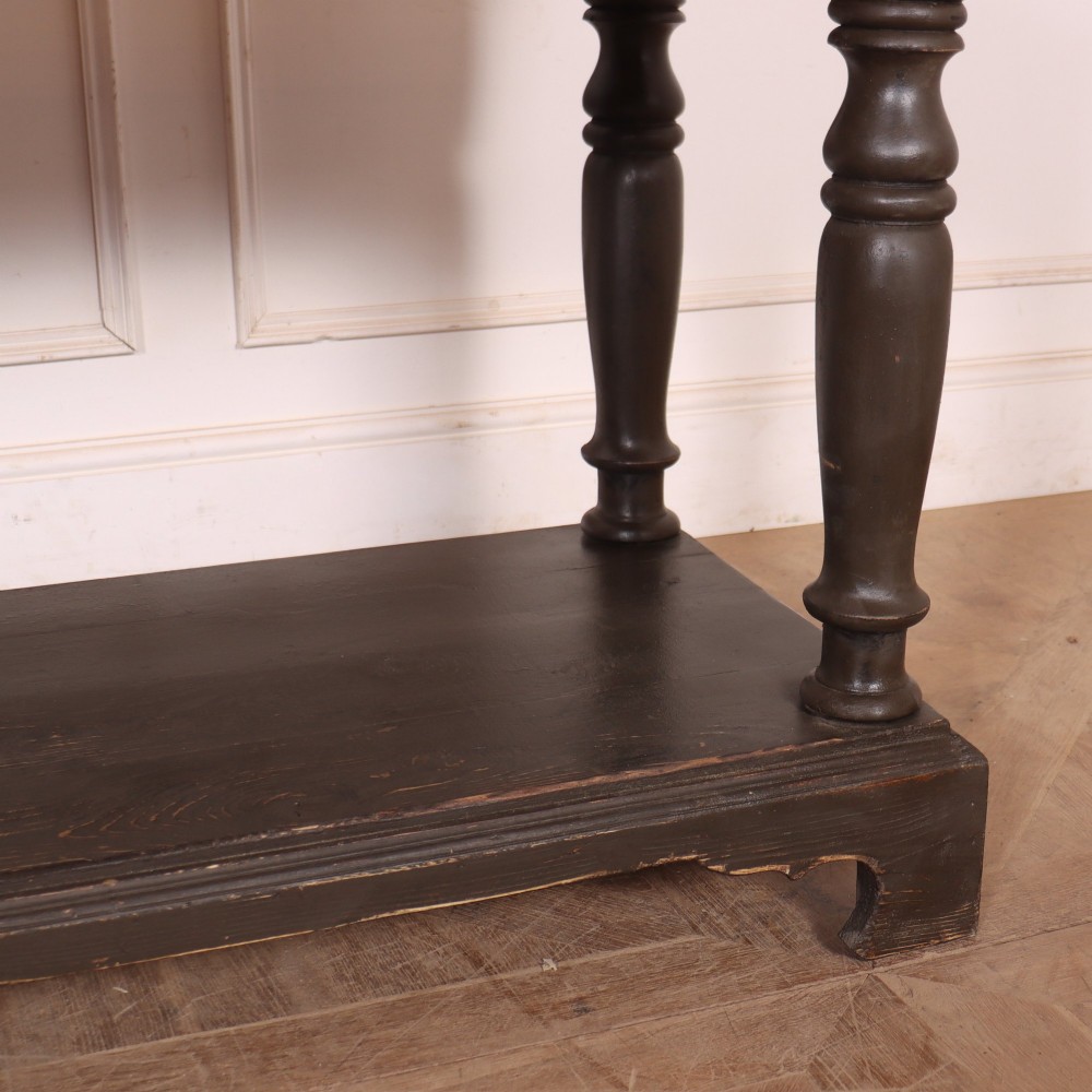 An antique dark grey painted English potboard dresser base featuring four drawers with brass handles, turned legs, and an open lower shelf. View VI