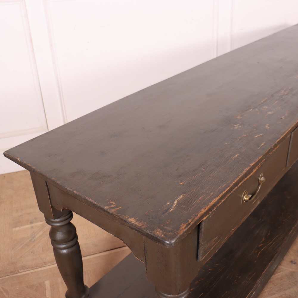 An antique dark grey painted English potboard dresser base featuring four drawers with brass handles, turned legs, and an open lower shelf. View IX