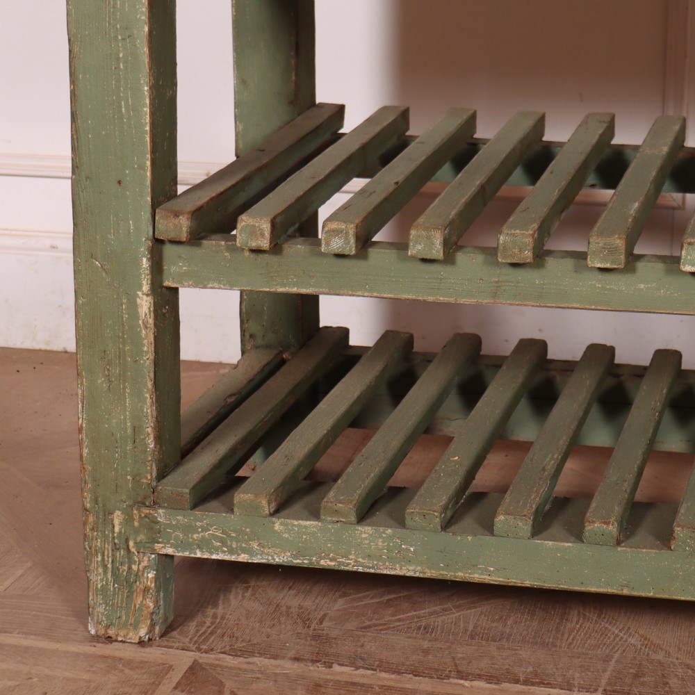 A rustic green painted Scottish dresser base with an unpainted pine top, two drawers with iron metal drop handles, and two slatted lower shelves. View III