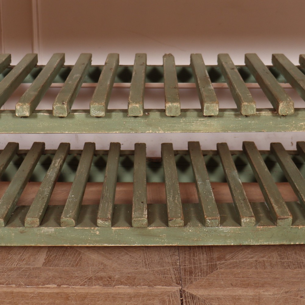 A rustic green painted Scottish dresser base with an unpainted pine top, two drawers with iron metal drop handles, and two slatted lower shelves. View V