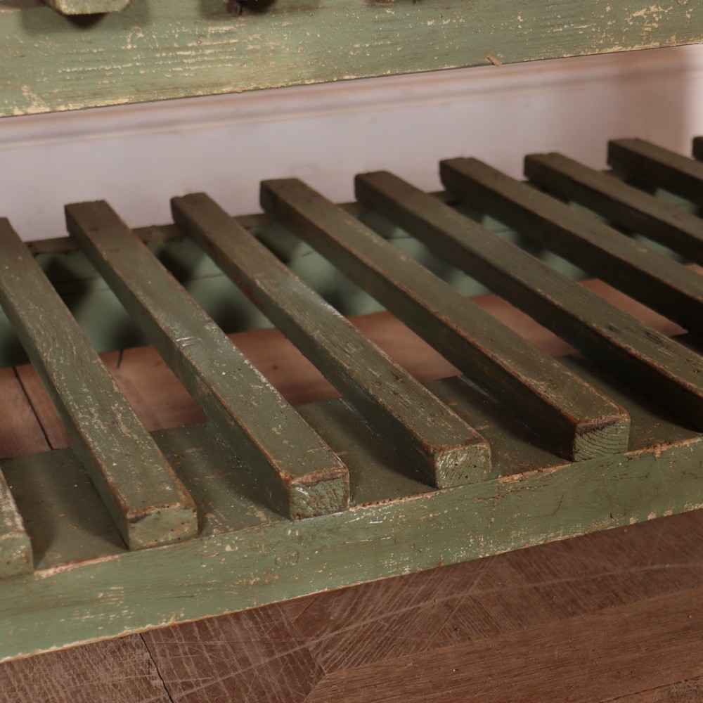 A rustic green painted Scottish dresser base with an unpainted pine top, two drawers with iron metal drop handles, and two slatted lower shelves. View VIII