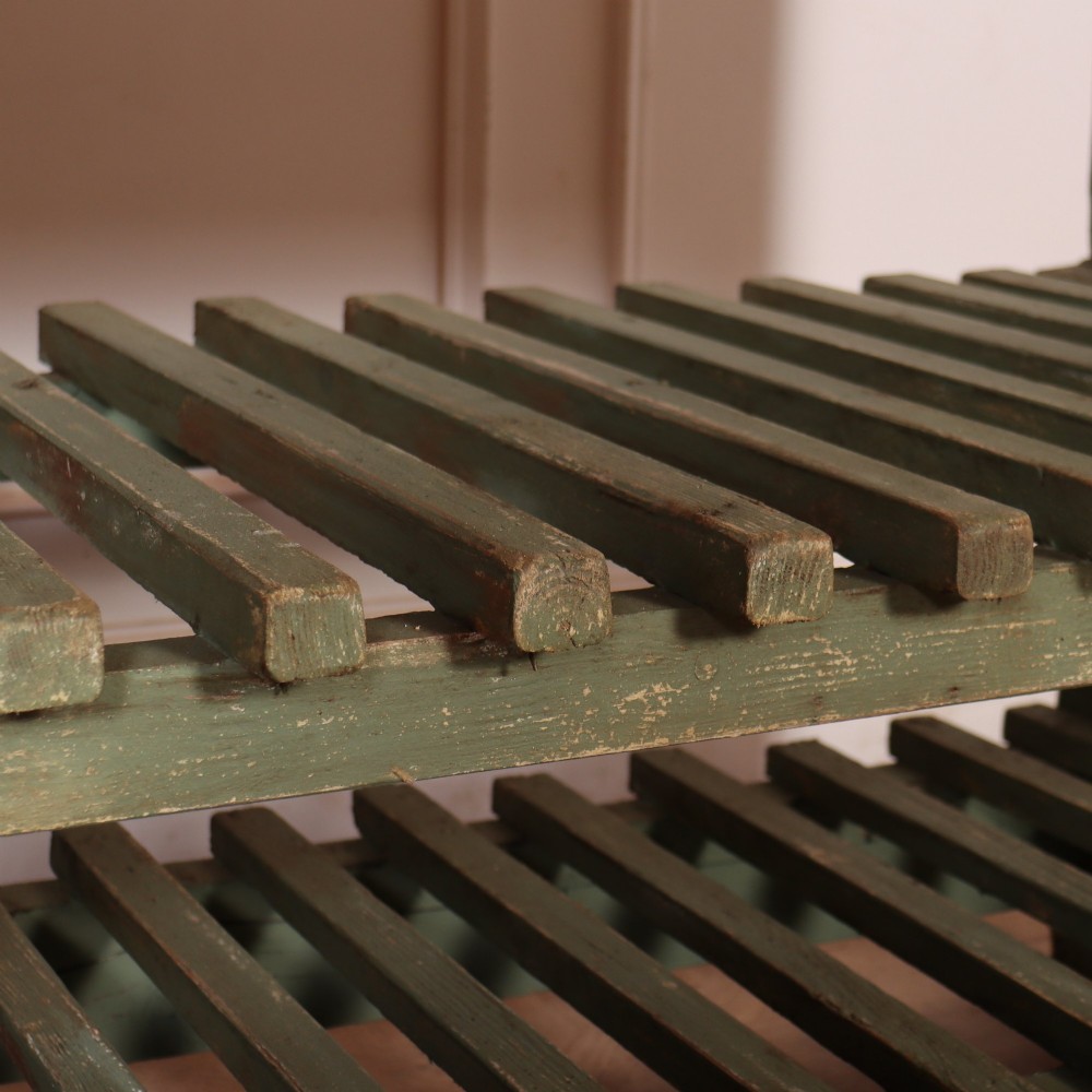 A rustic green painted Scottish dresser base with an unpainted pine top, two drawers with iron metal drop handles, and two slatted lower shelves. View IX