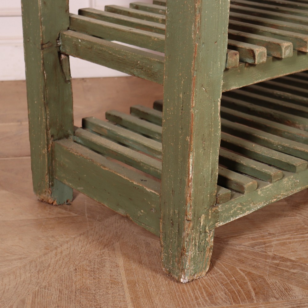 A rustic green painted Scottish dresser base with an unpainted pine top, two drawers with iron metal drop handles, and two slatted lower shelves. View XI