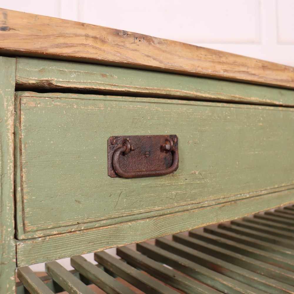 A rustic green painted Scottish dresser base with an unpainted pine top, two drawers with iron metal drop handles, and two slatted lower shelves. View XII