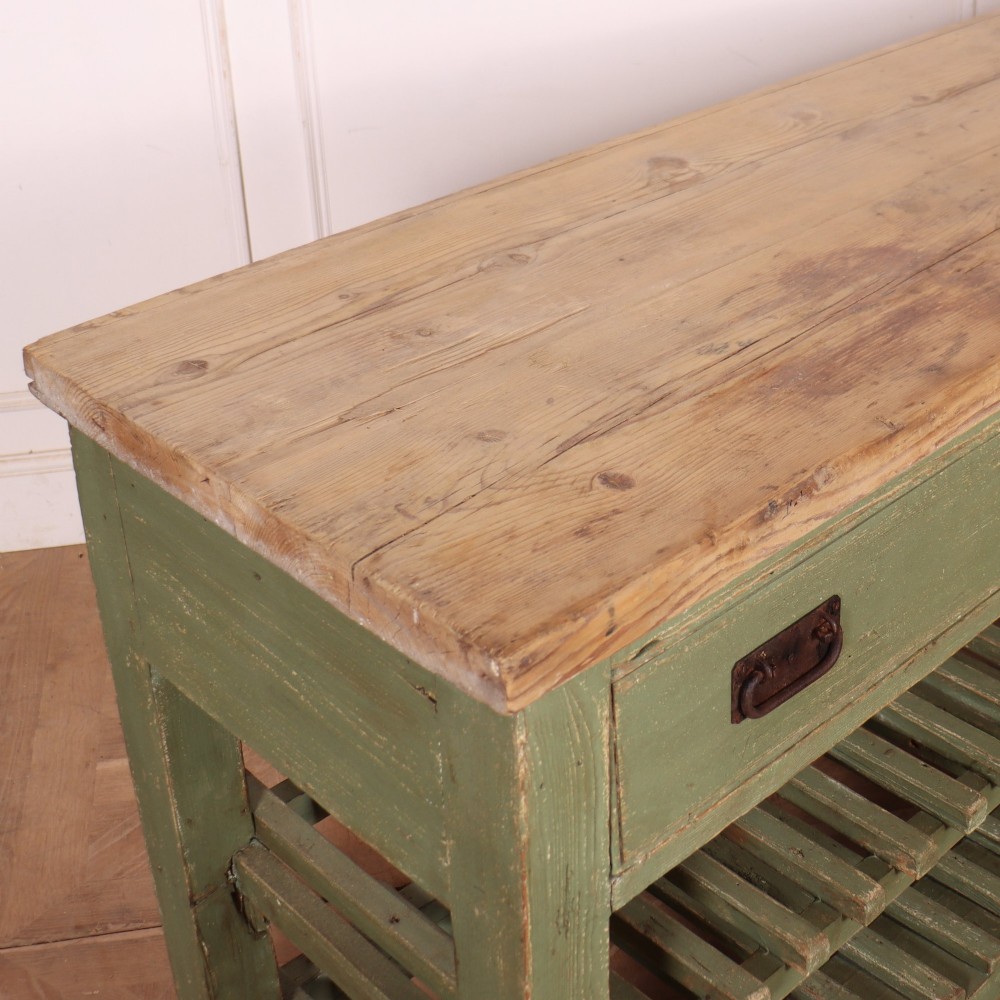 A rustic green painted Scottish dresser base with an unpainted pine top, two drawers with iron metal drop handles, and two slatted lower shelves. View XIII