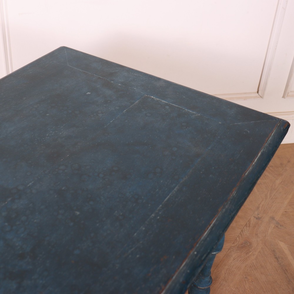 A rectangular blue painted wooden lamp table featuring turned legs, a single drawer with a metal pull, a scalloped apron, and a curved X-shaped stretcher. View IX