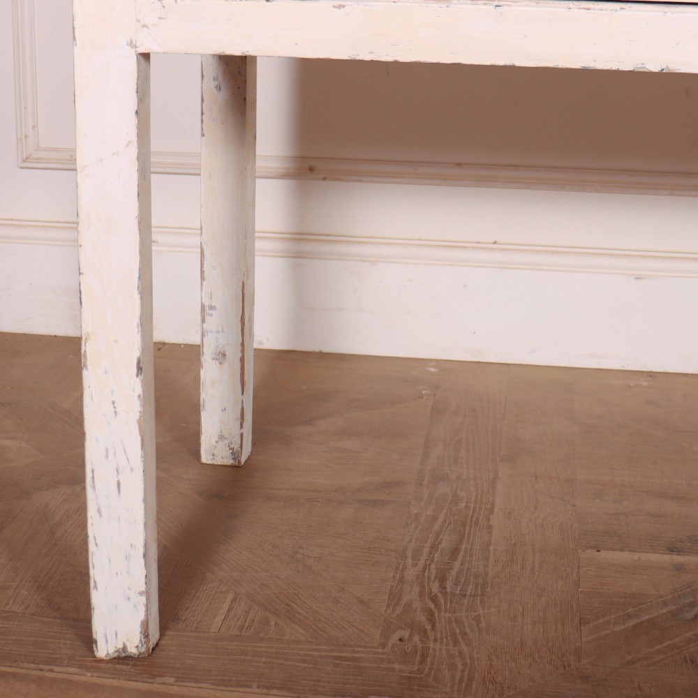 An antique English country dresser base featuring a natural wooden top, three off-white painted drawers with circular brass knobs, and four square straight legs. View III