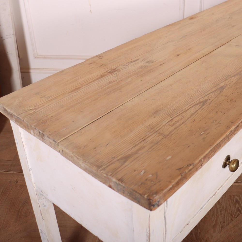 An antique English country dresser base featuring a natural wooden top, three off-white painted drawers with circular brass knobs, and four square straight legs. View VIII
