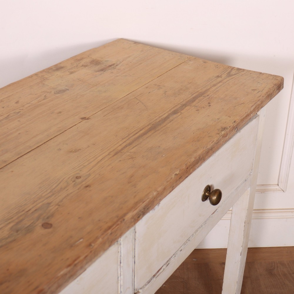 An antique English country dresser base featuring a natural wooden top, three off-white painted drawers with circular brass knobs, and four square straight legs. View IX