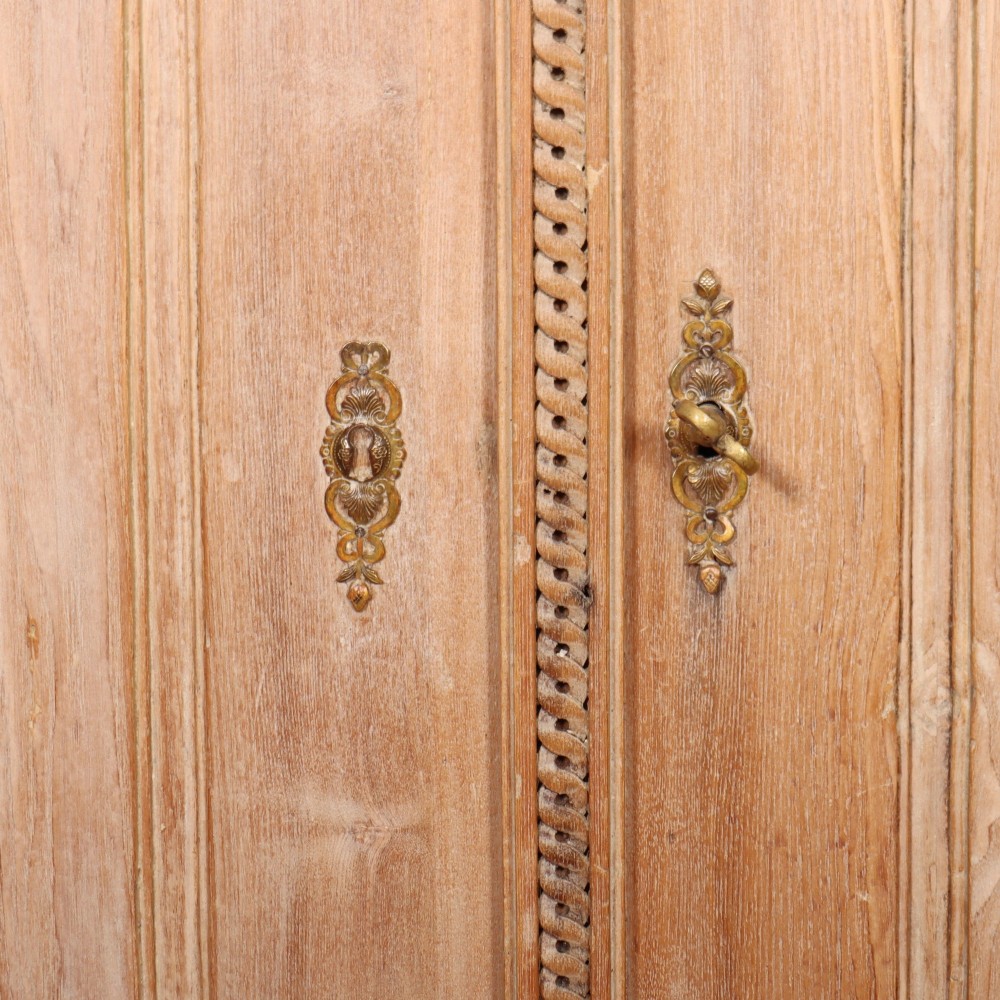 A pale wood bowfront buffet featuring two panelled doors, carved side detailing, and brass keyholes. View VI