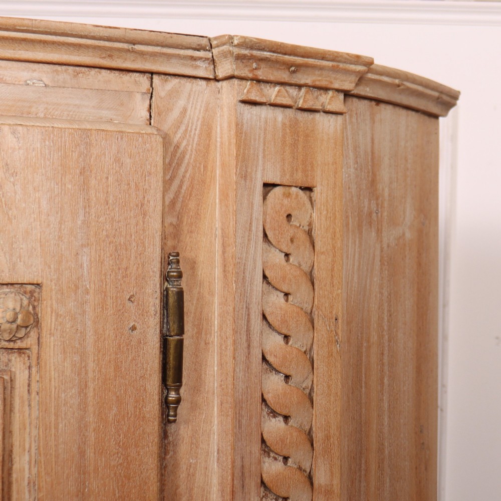 A pale wood bowfront buffet featuring two panelled doors, carved side detailing, and brass keyholes. View VII