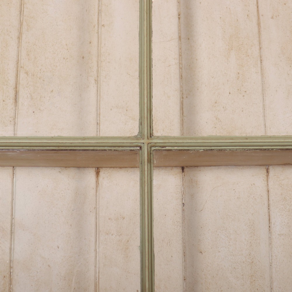 A large sage green painted dresser featuring an upper glazed display cabinet with sliding doors, lower drawers with brass drop handles, and panelled cupboard doors. View III