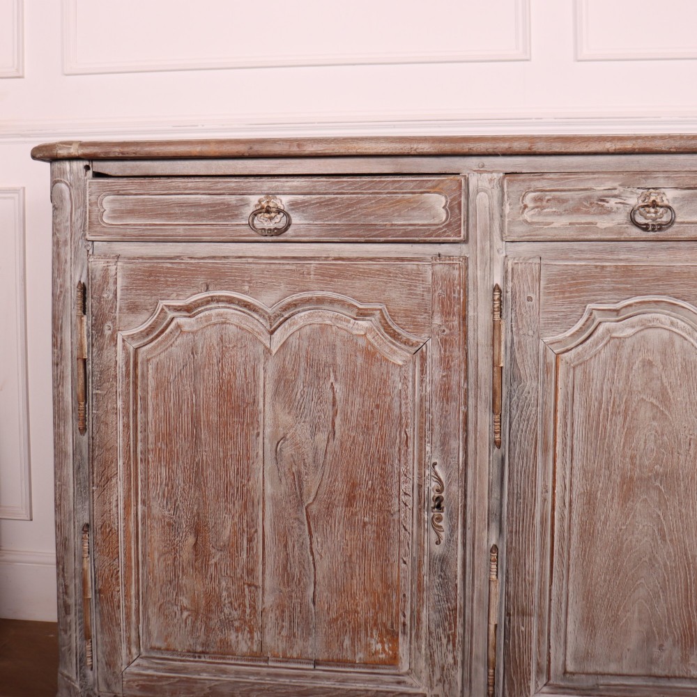 A large four-door French provincial enfilade made from bleached oak, featuring raised panel cupboard doors, four top drawers, and a scalloped apron. View II