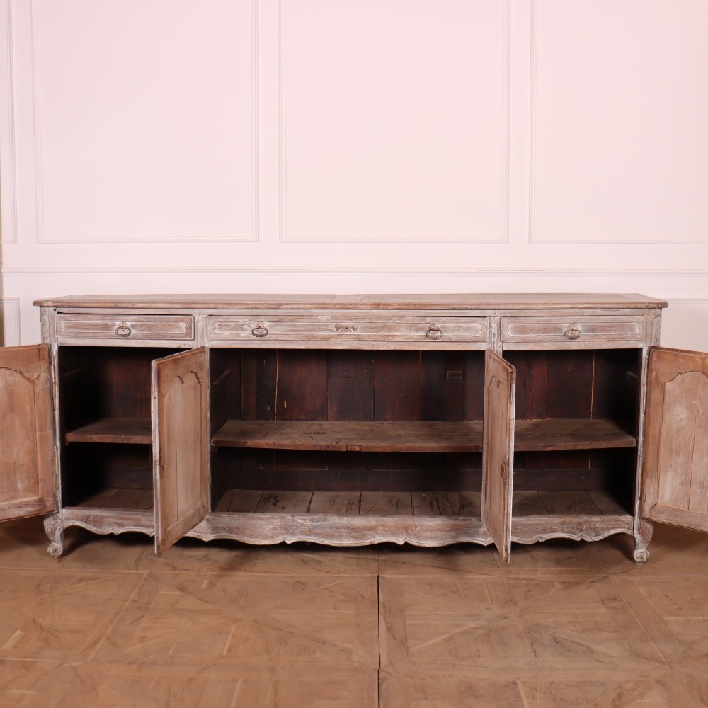 A large four-door French provincial enfilade made from bleached oak, featuring raised panel cupboard doors, four top drawers, and a scalloped apron. View VIII