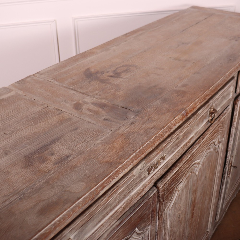A large four-door French provincial enfilade made from bleached oak, featuring raised panel cupboard doors, four top drawers, and a scalloped apron. View XIII