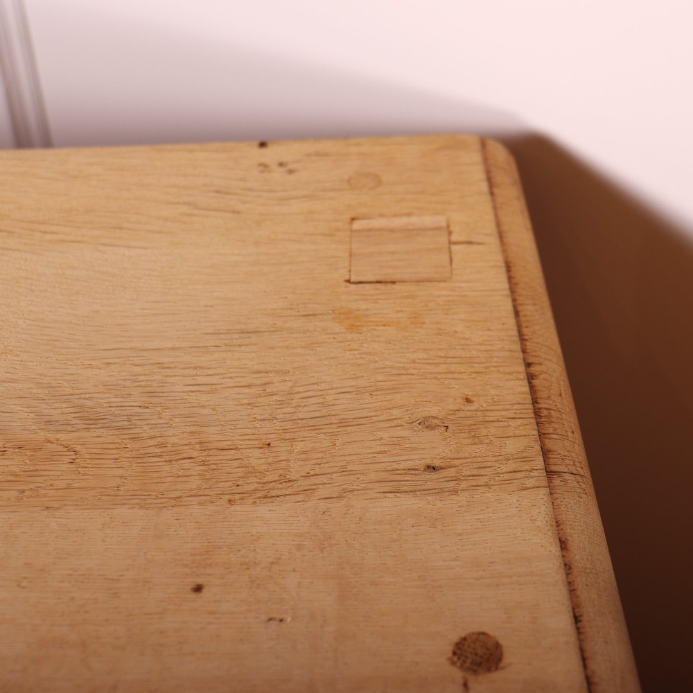 A wide bleached oak dresser base featuring six drawers with brass drop handles and two arched panelled cupboard doors. View XII