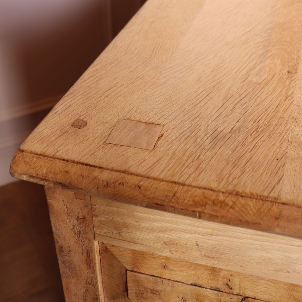 A wide bleached oak dresser base featuring six drawers with brass drop handles and two arched panelled cupboard doors. View XIII