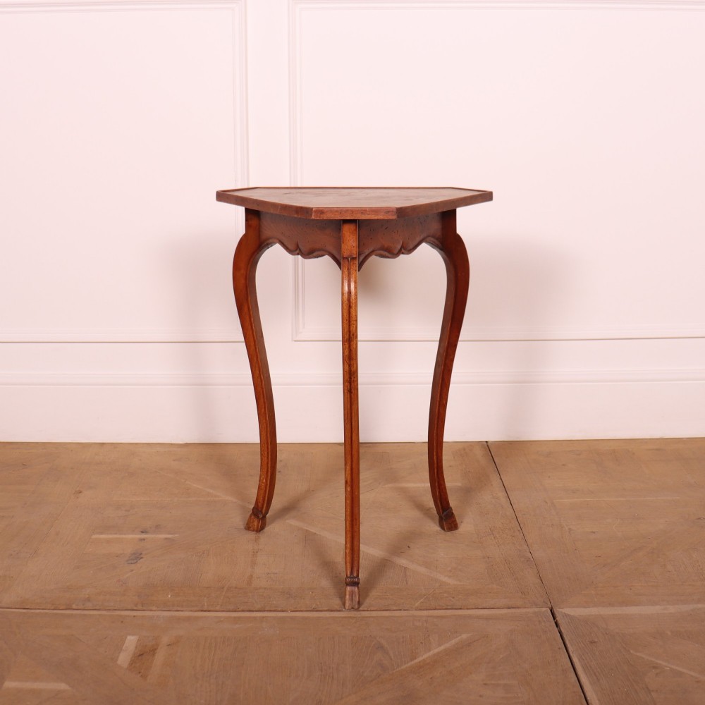 A French cherrywood side table featuring three slender cabriole legs, a shaped top, and a contoured apron with a warm brown finish.