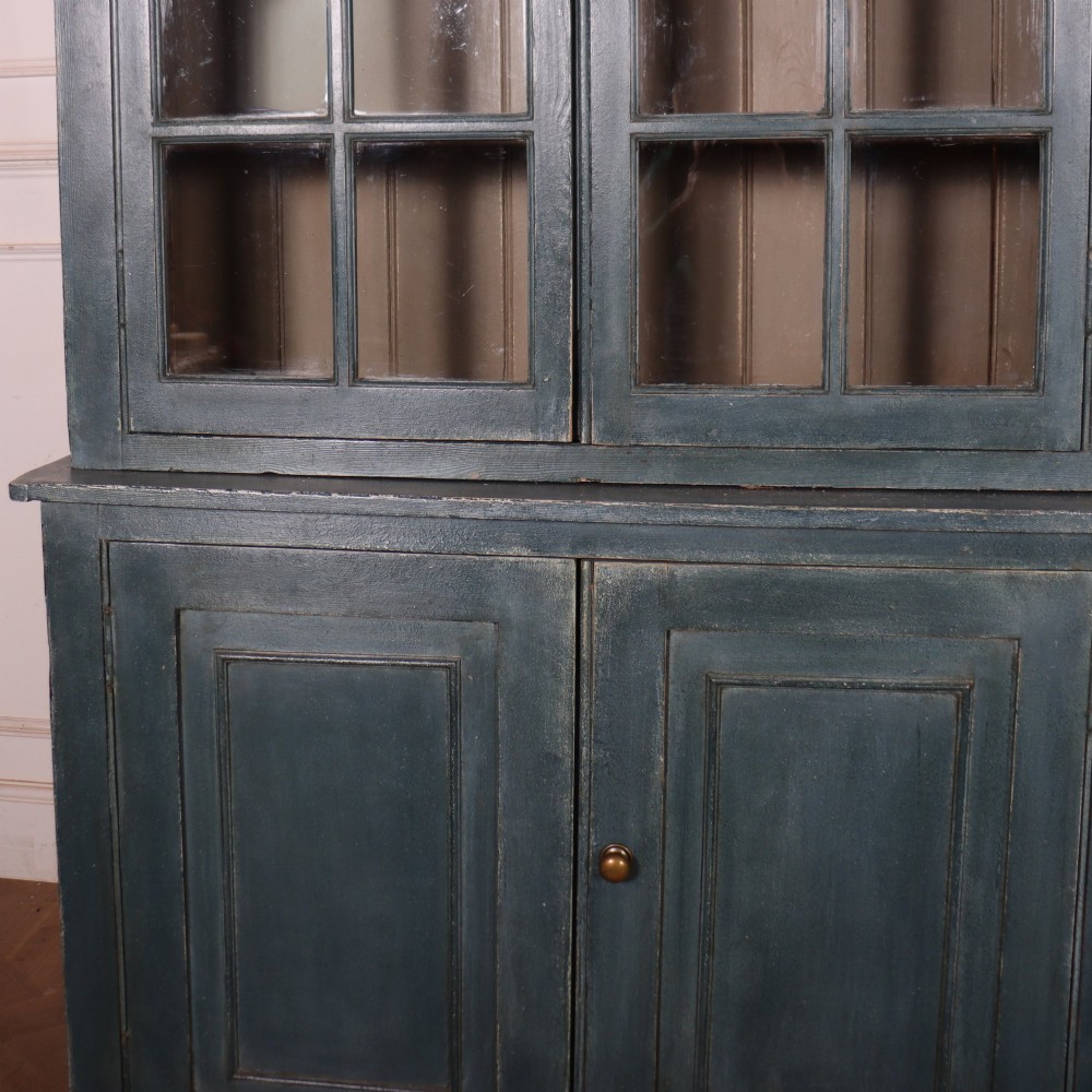 A large slate blue painted wood kitchen dresser featuring a four-door glazed upper cabinet over a four-door panelled cupboard base. View III