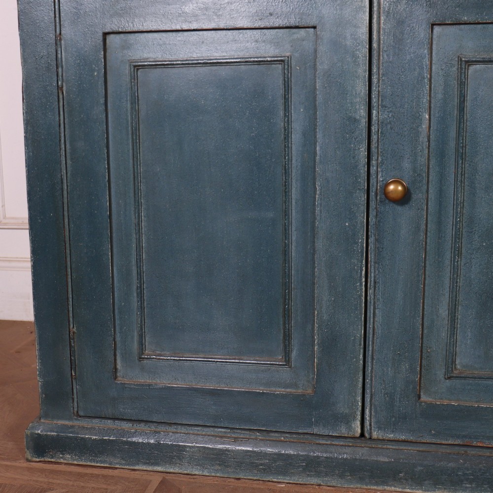 A large slate blue painted wood kitchen dresser featuring a four-door glazed upper cabinet over a four-door panelled cupboard base. View IV