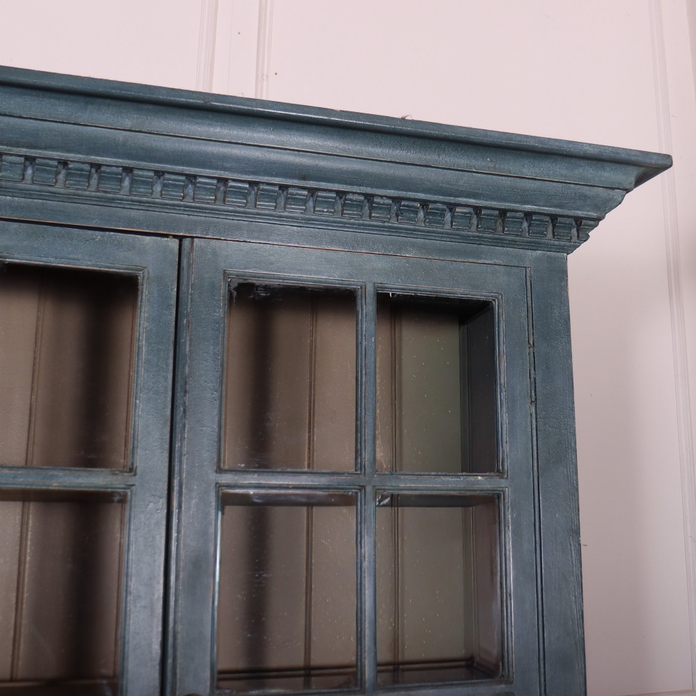 A large slate blue painted wood kitchen dresser featuring a four-door glazed upper cabinet over a four-door panelled cupboard base. View V