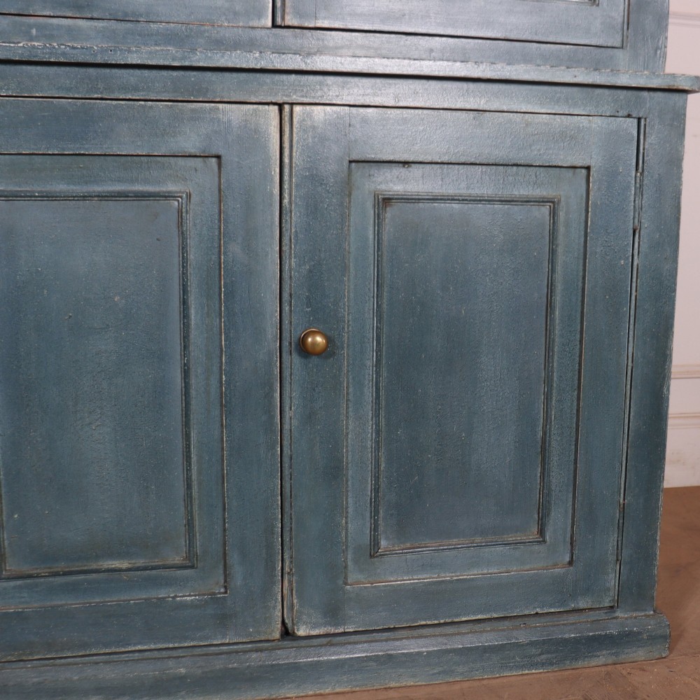 A large slate blue painted wood kitchen dresser featuring a four-door glazed upper cabinet over a four-door panelled cupboard base. View VI