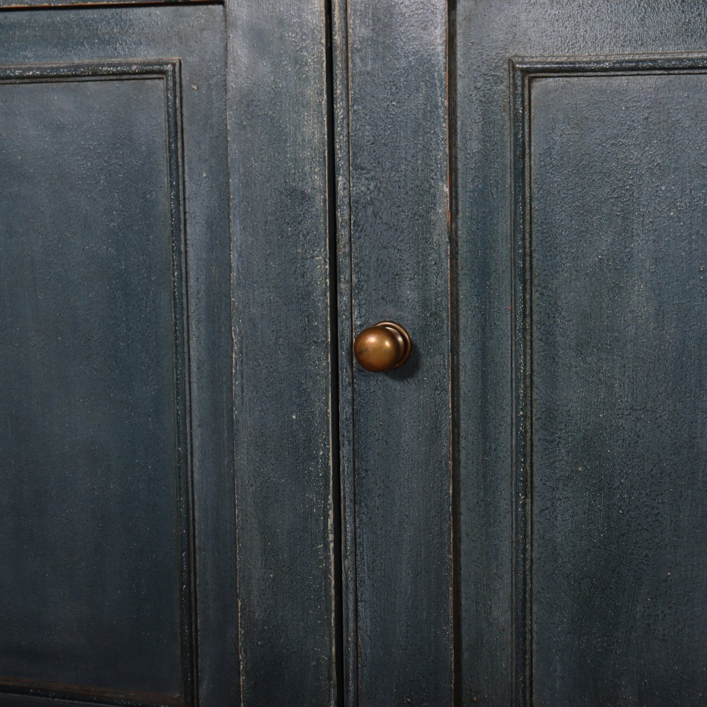 A large slate blue painted wood kitchen dresser featuring a four-door glazed upper cabinet over a four-door panelled cupboard base. View VII