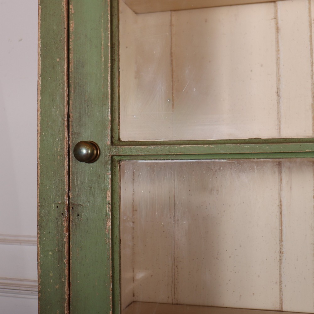 A large green painted timber cabinet featuring a two-door glazed upper section with multiple glass panes above a four-door solid panelled lower cupboard. View IV