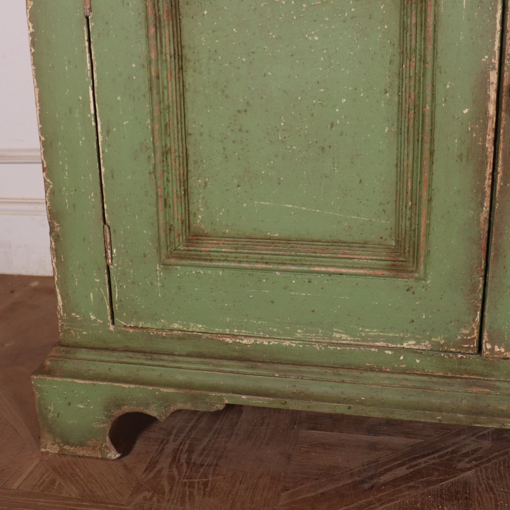 A large green painted timber cabinet featuring a two-door glazed upper section with multiple glass panes above a four-door solid panelled lower cupboard. View VI