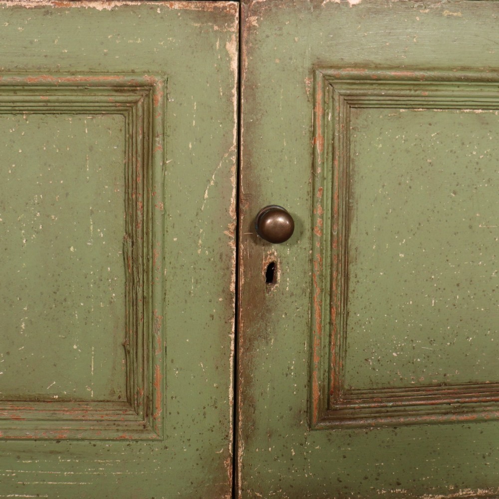A large green painted timber cabinet featuring a two-door glazed upper section with multiple glass panes above a four-door solid panelled lower cupboard. View IX
