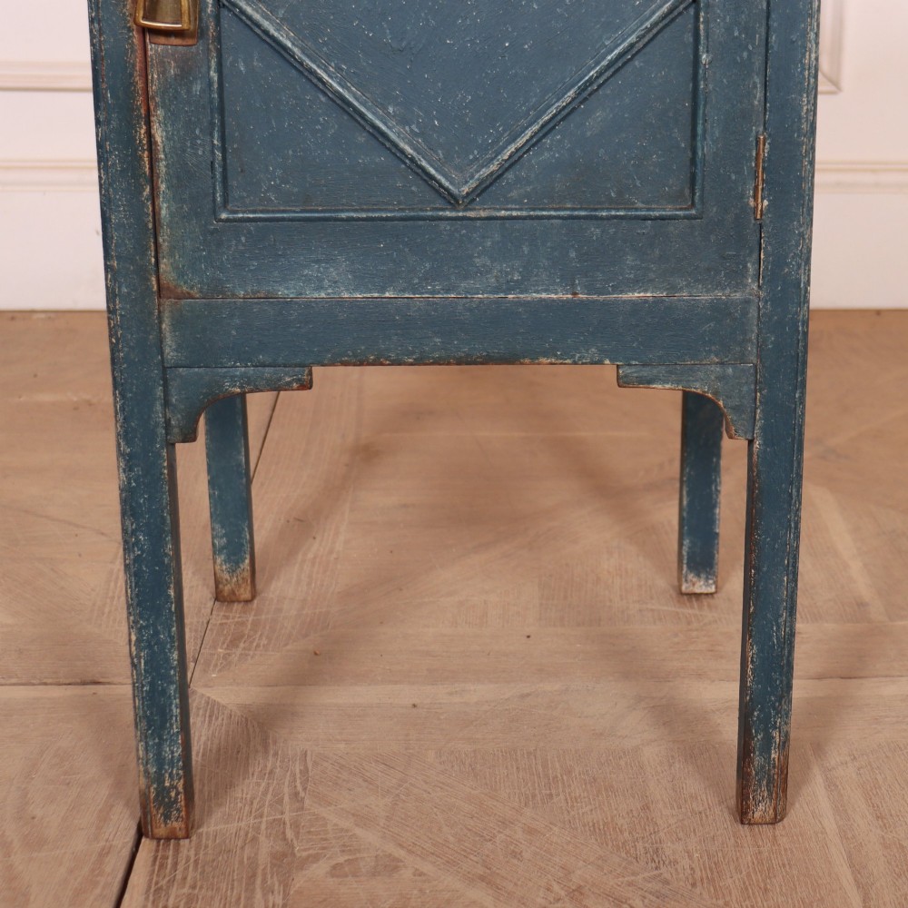 A small Swedish blue painted wood bedside cabinet with a carved diamond panel on the single door and a brass pull handle. View III