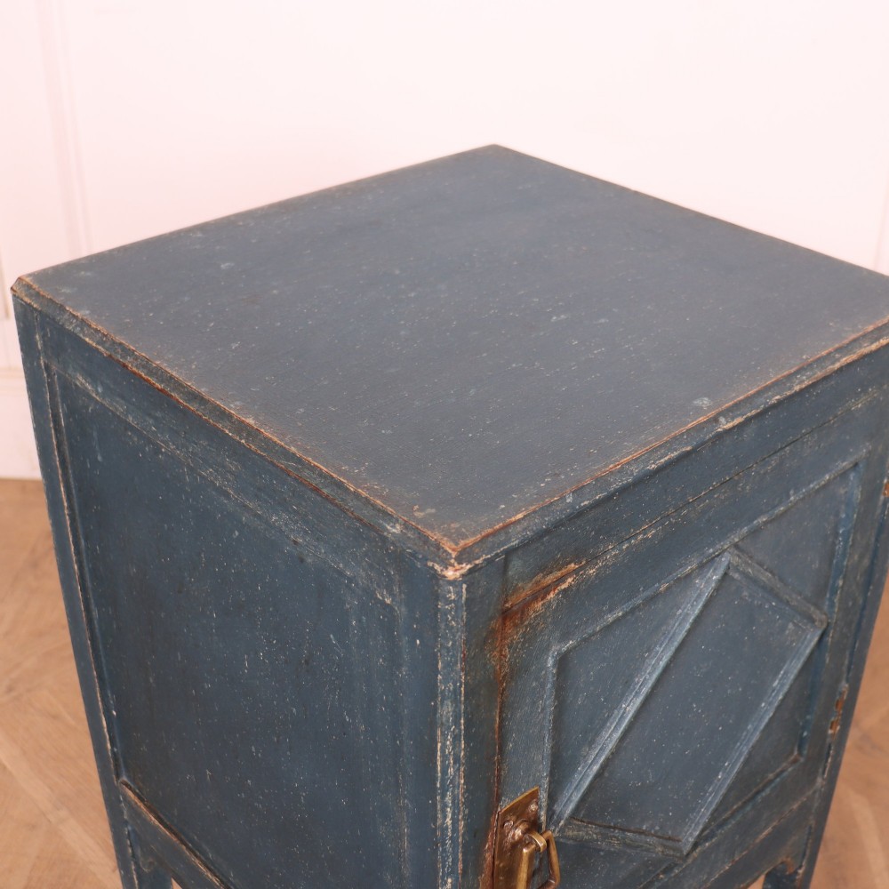 A small Swedish blue painted wood bedside cabinet with a carved diamond panel on the single door and a brass pull handle. View VII
