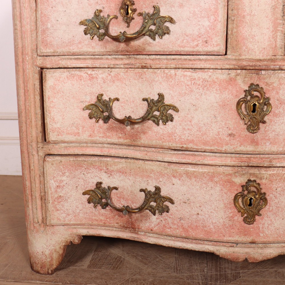 A Louis XV style French painted commode featuring a serpentine front, grey marble top, four drawers with rococo brass handles, and a distressed pale pink painted finish. View III