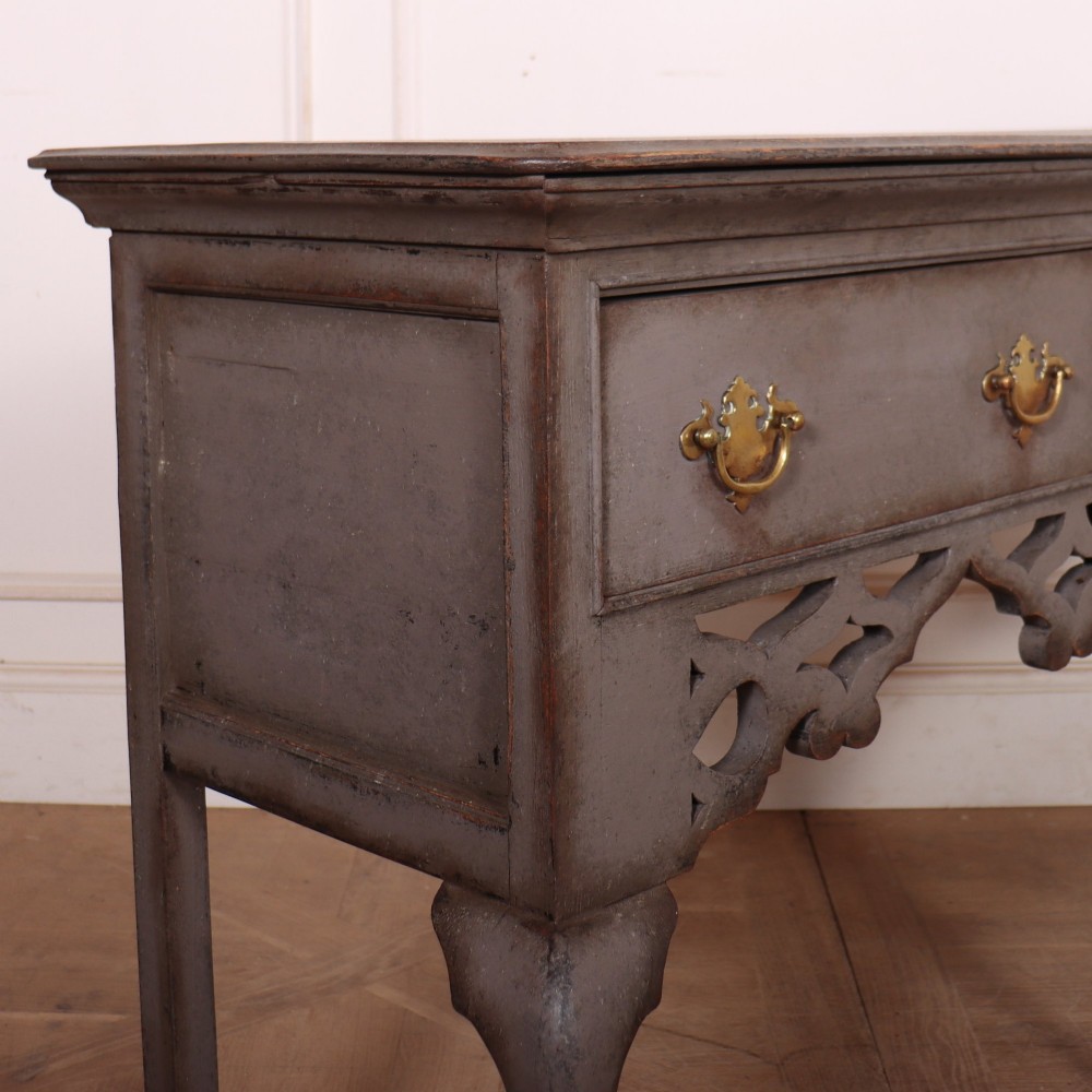 A grey-painted antique dresser base featuring three drawers with brass handles, a decorative pierced fretwork apron, and cabriole legs. View VIII